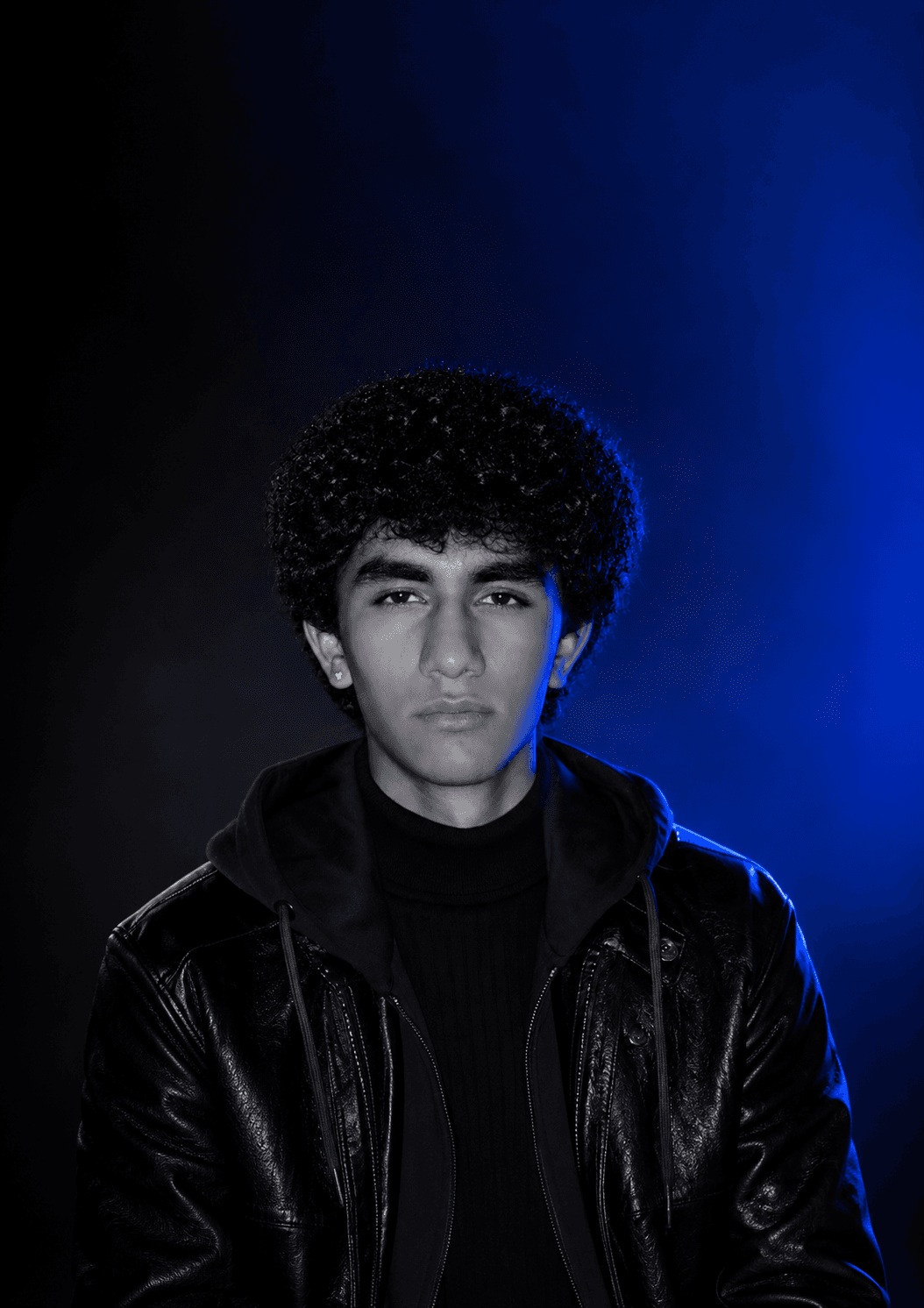 Tanish Bhavsar in a leather jacket, lit in blue